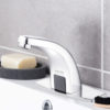 Closeup of a shiny modern faucet soap and toothbrushes